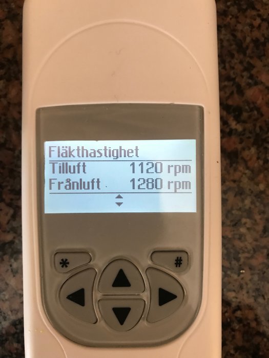 Ventilationssystemets handenhet som visar fläkthastigheter för tilluft och frånluft.