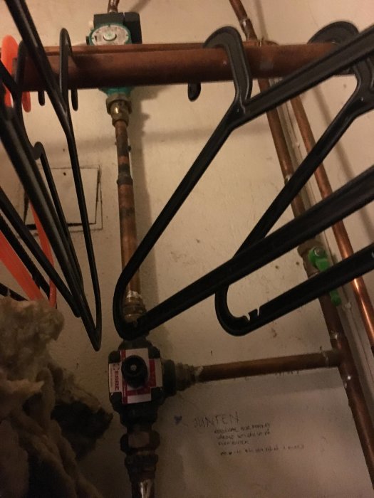 Översikt av värmesystemets skåp med nio kopplade slingor och en grön cirkulationspump samt ventiler och rörarrangemang.