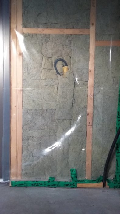Isolering bakom träregelstomme med framtida installation av rör.