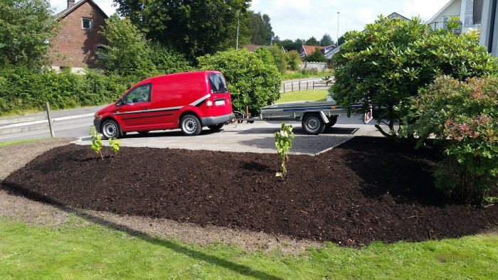 Nyplanterade syrener och nyanlagd parkering för släpkärra bredvid röd skåpbil.