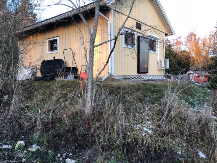 Ett gult garage med en röd stakkäpp markerande tomtgränsen, visande avståndet från gränsen till byggnaden.