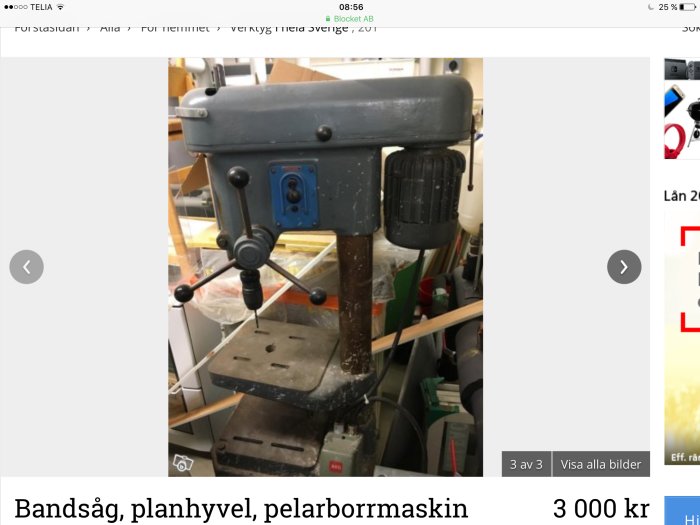 En använd pelarborrmaskin i en verkstad med synlig märkning och kontrollpanel.