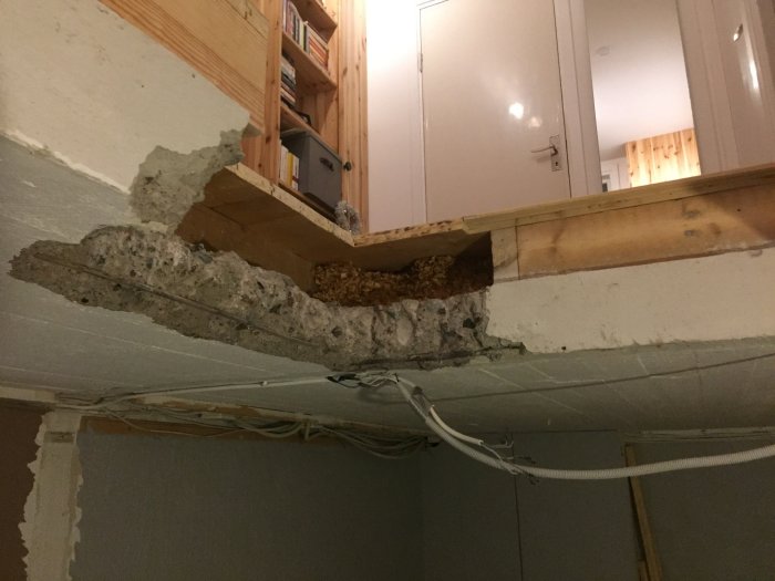 Revnet loft med synlige træ- og betonstrukturer samt spånmateriale til en repos, viser et byggeprojekt i hjemmet.
