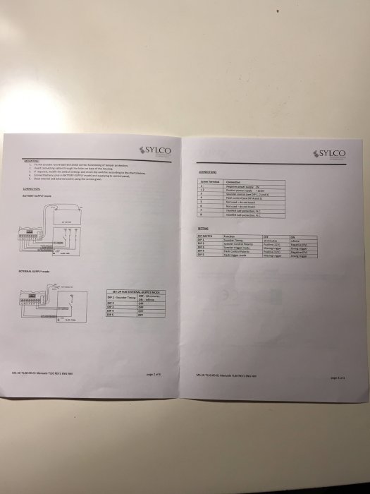 Illustration och tabell över anslutningar och dipswitch-inställningar för en säkerhetsenhet från SYLCO, visas på två blad.