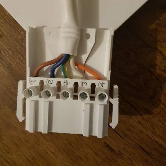 Öppnad anslutningskontakt för LVI-radiator med färgkodade sladdar redo för elinstallation.