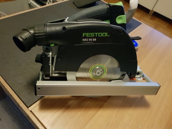 Festool sänksåg HKC 55 EB med monterat parallellanslag på ett mörkt underlag.