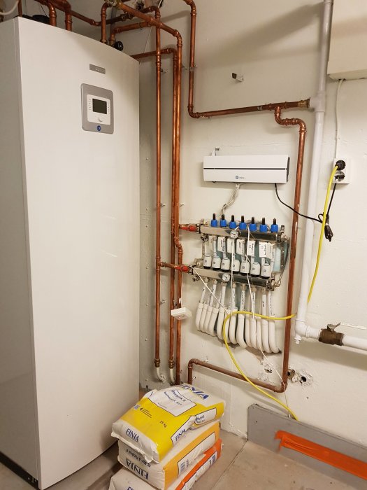 Värmepanna och rörinstallationer i pannrum, före och efter renovering.
