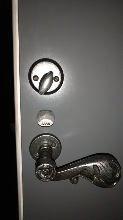 Nyinstallerat ASSA 2002 lås med nyckelhål och dekorativt svart handtag på en dörr.