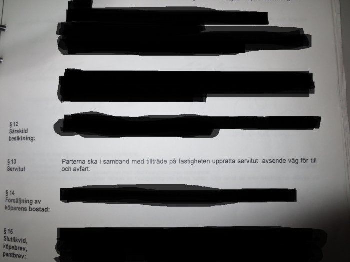 Del av ett köpekontrakt med text om servitut, övrig text censurerad med svarta streck.