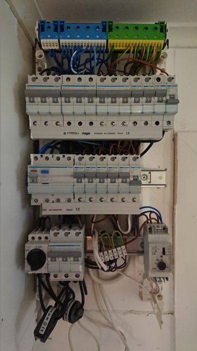 Elektriskt säkringsskåp med öppen ledning, dvärgbrytare och flera anslutna kablar och komponenter.