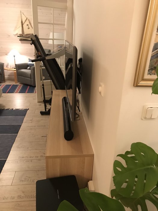 Laminatbit som står på en bänk bredvid en TV, tänkt att dölja kablar.