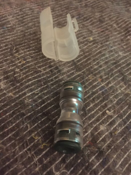 En fiberkoppling för att sammanfoga två stycken lila 14mm fibrör för husinstallation.