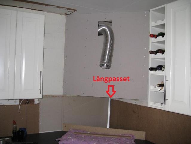 Renovering av kök med ett långpass placerat i hörnet, halvfärdig skivmontering och osatt kakel.