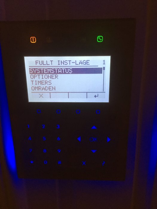Digital kontrollpanel för husets installation med texten "FULLT INST-LÄGE 1" och menyval på skärmen.