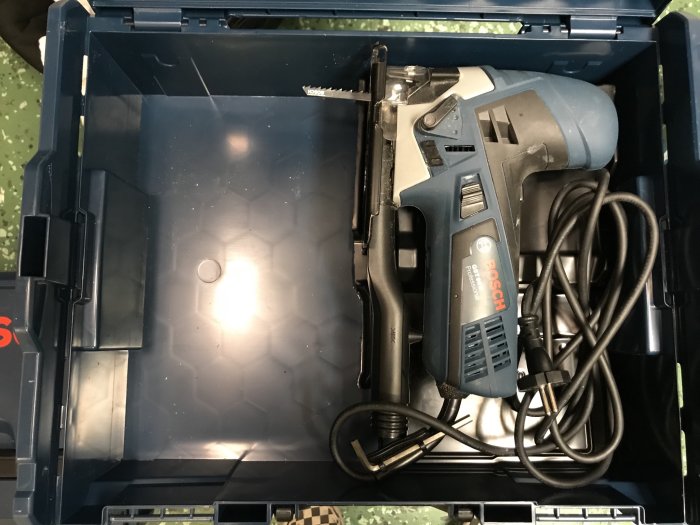 En modifierad verktygslåda med en elektrisk häftpistol och dess sladd prydligt lagd inuti, anpassad för att passa verktyget.
