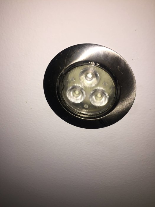 Inbyggd taklampa med fyra LED-ljuskällor och rundad metallkant mot vit bakgrund.