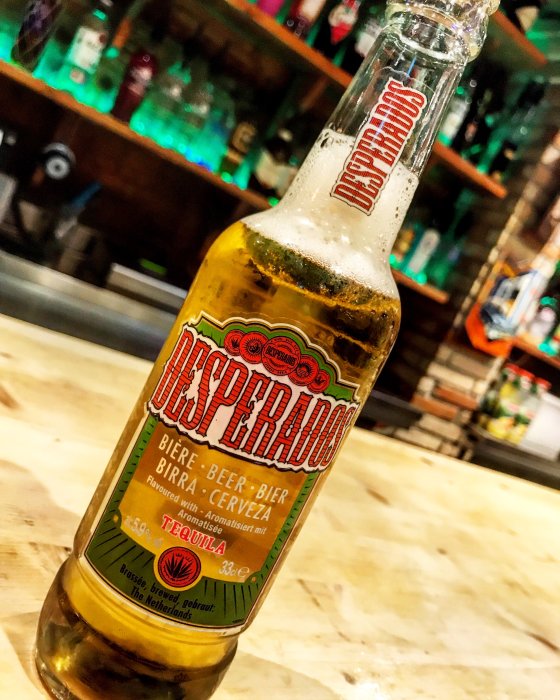 Flaska Desperados öl med tequilasmak på en bardisk.