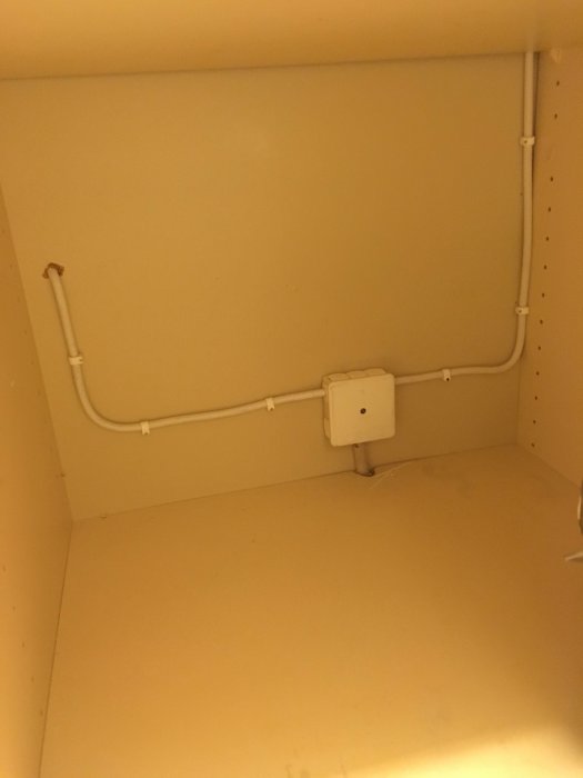 Elinstallation med dosa och kablar inuti ett ljust skåp, relaterat till en planerad renovering och omorganisation.