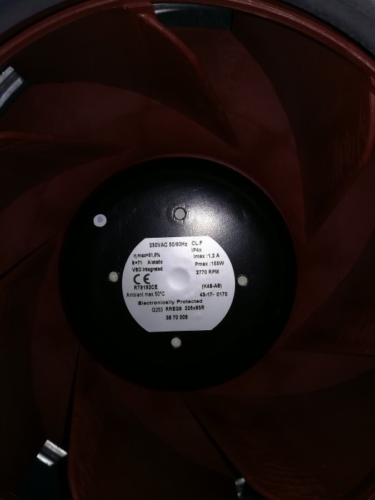 Bild på en fläktmotor med etikett som visar specifikationer inklusive "230VAC 50/60Hz" på ett ventilationsaggregat.