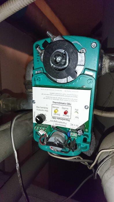 Elektrisk motor till ventilationssystem med mätare och ledningar i dunkel miljö.