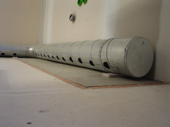 Ventilationsrör på golv med en liten öppning för luftcirkulation vid bänkskåp.