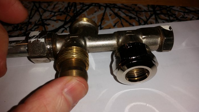 Hand håller en Danfoss inloppskoppling bredvid ett begagnat element, passar ej ihop.