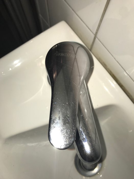 Kromad Teorema blandarhandtag monterad på vit sanitetsporslin, återspeglar en sökning efter reservdelar.