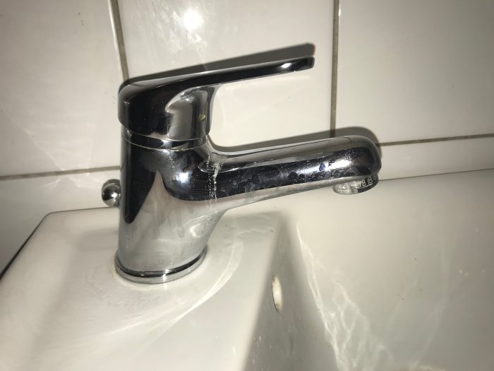Kromad Teorema-blandare i badrum med tydliga tecken på läckage.