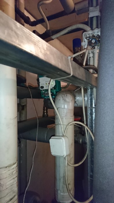 Installation av rör och kopplingar i ett skrymsle, inklusive en elektronisk komponent och kablar.