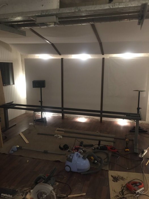 Renoveringsarbete med stålprofiler, verktyg och material spridda på ett bygge inomhus.