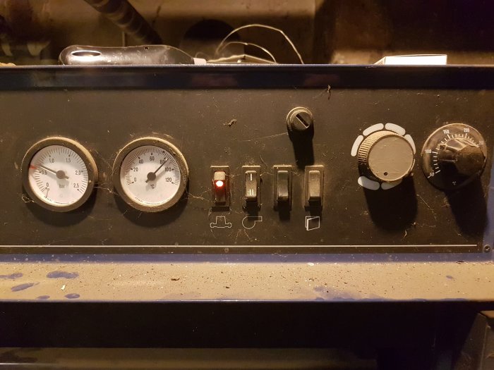 Panel på en panna med termometrar, manometrar, strömbrytare och justeringsknappar.