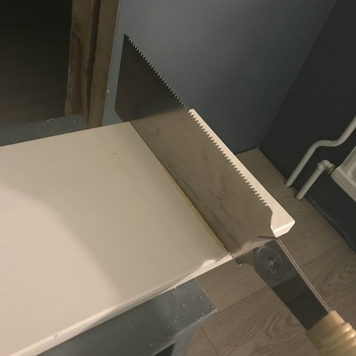 Sågblad som sticker upp genom sågat arbetsstycke för byggnadsarbete.