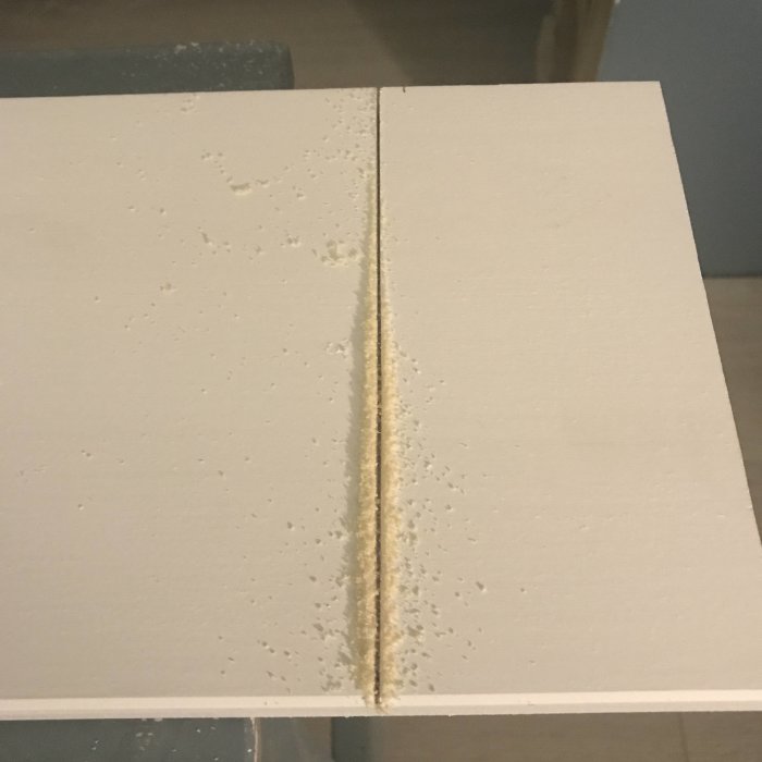Närbild av gipsvägg med skarv och spackel efter installation av en dörr eller valv.