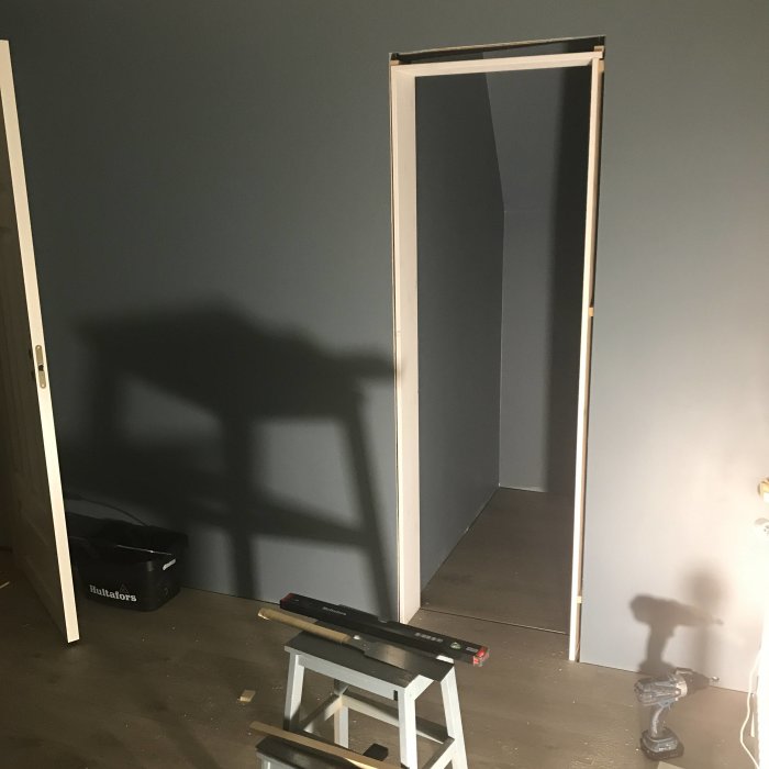 Nyinstallat dörrvalv i en vägg, arbetsmaterial och verktyg syns i förgrunden.