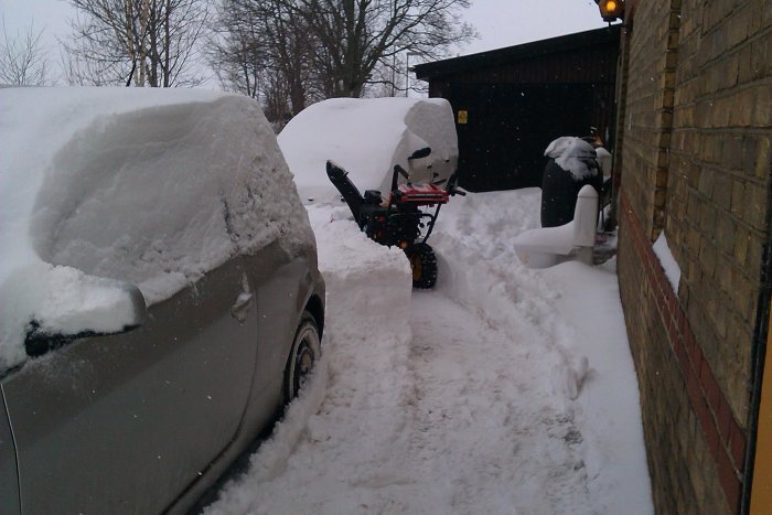 Snötäckt scenario med bil och snöslunga vid hus, Tomelilla mars 2013.