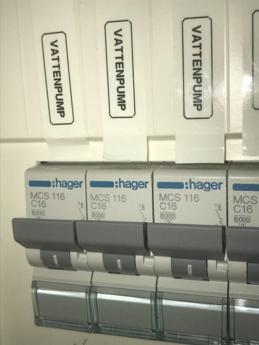 Närbild av en elcentral med tre märkta säkringar "Vattenpump" och Hager MCS 116 C16 automatsäkringar.
