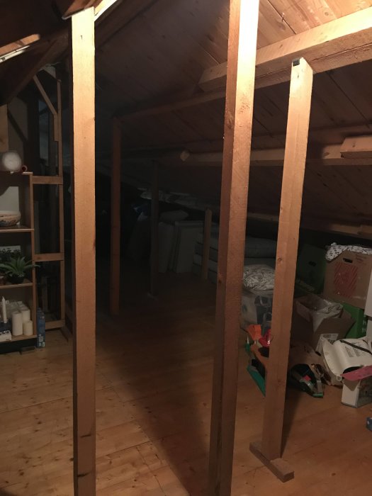 Vinden i ett hus med oregelbundet placerade träpinnar och synliga takbjälkar som kan behöva ombyggnad för att klara rumshöjdskrav.