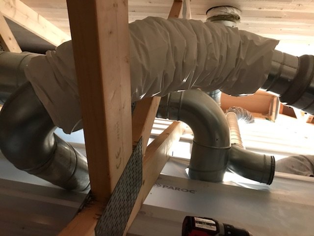 Ventilationsrör installerade mellan takstolar i en byggkonstruktion.