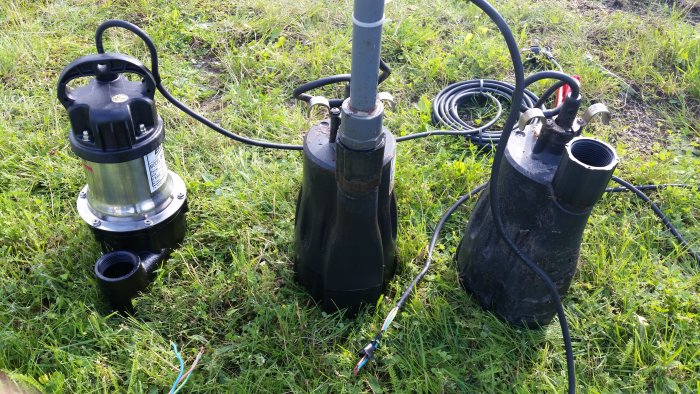 Fyra budgetpumpar på gräs för rensningsarbete vid ett Baga reningsverk, med synliga elkablar.