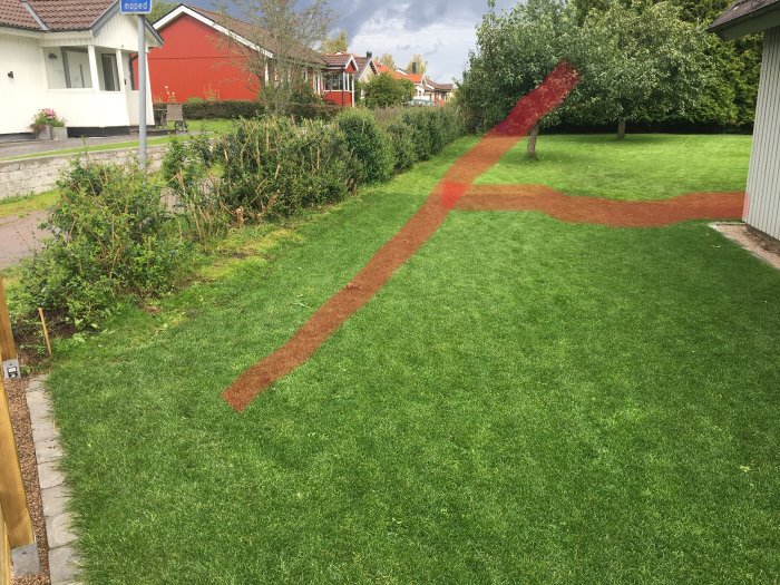 Gräsmatta med en röd linje där användaren planerar att lägga dräneringsrör för att undvika vattenskador.