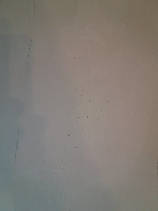 Vägg med luftbubblor i bredspackling under renoveringsarbete.