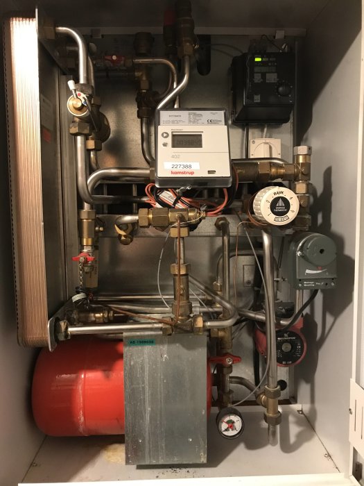 Värmecentral med rörkopplingar, mätare, expanderkärl och diverse ventiler.