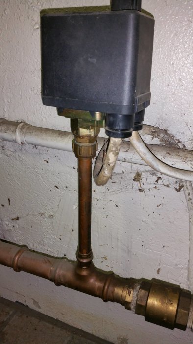 Tryckströmbrytare monterad på kopparledning med T-koppling planering för manometerinstallation.