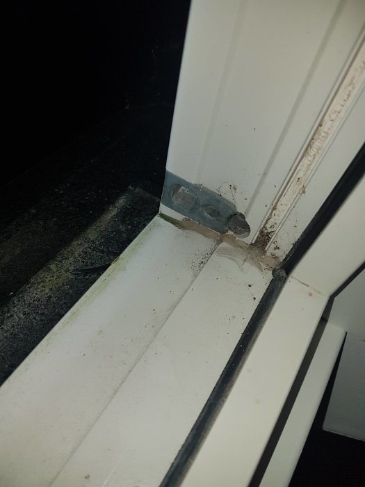 Bild på hörnet av en fönsterkarm med synliga vattenskador och försök till tätning där det eventuellt läcker.