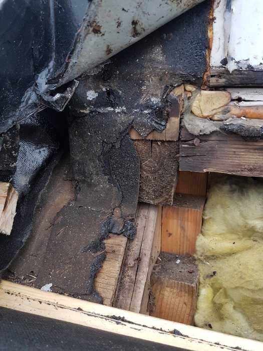 Skadad fönsterkupa med synliga vattenskador och tätningsförsök på ett hus.