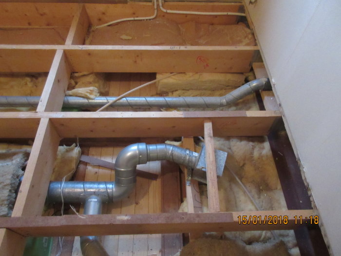 Upprivet golv i renoveringsprojekt med synlig ventilation och isolering.