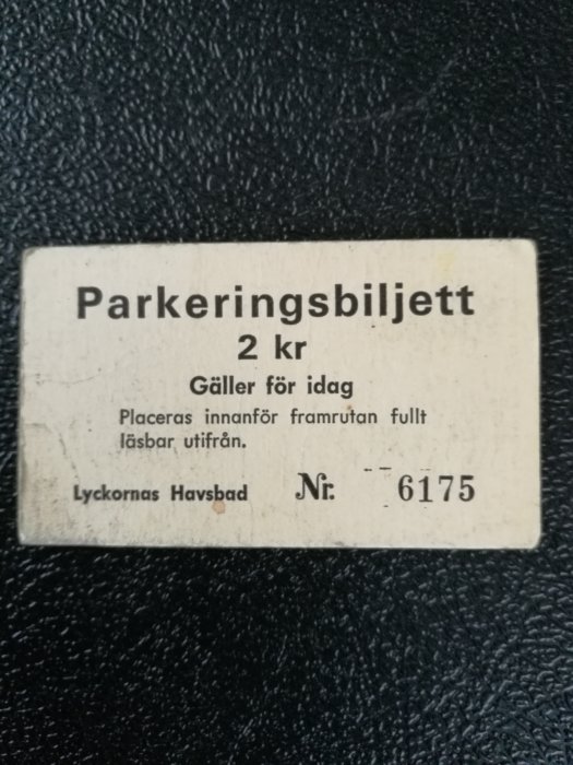 En sliten parkeringsbiljett på 2 kr för Lyckornas Havsbad med nummer 6175.