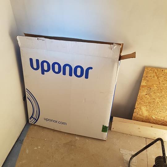 Uponor-emballage i ett hörn av ett byggprojekt som indikerar pågående VVS-arbete.