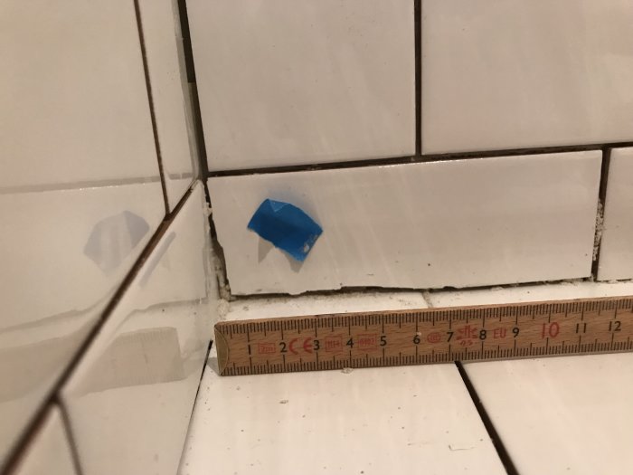 Ojämnt kakel med varierande fogbredder mätt med tumstock, slarvigt hörnarbete i badrum.
