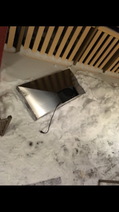 Ventilationsfläkt monterad i taket med nedfallen isolering runtomkring och synlig kabel.